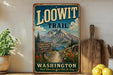 A vintage-style metal sign for the Loowit Trail in Washington, featuring a mountain landscape and a sign that says "A Hiking Journey Through History and Beauty".