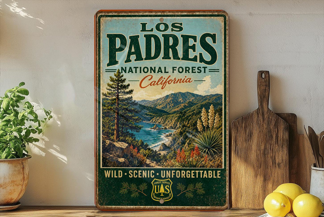 A vintage-style metal sign for the Los Padres National Forest in California, featuring a scenic landscape with mountains, trees, and a river.