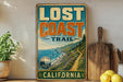 a vintage-style metal sign that reads "Lost Coast Trail" and "California", with a scenic illustration of a coastal landscape.