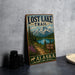 A vintage-style sign for the Lost Lake Trail in Alaska, featuring a scenic mountain landscape with a lake and pine trees.