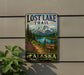 a sign for the Lost Lake Trail in Alaska, with a scenic mountain landscape and a trail sign indicating the trail's name.