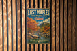 A vintage-style metal sign for Lost Maples State Natural Area in Texas, featuring a scenic landscape with trees and a river.