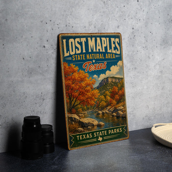 A vintage-style sign for Lost Maple State Natural Area in Texas, featuring a scenic landscape with a river and autumn trees.