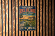 A vintage advertisement for rice culture in South Carolina, featuring a scenic landscape with a house and palm trees.