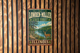 A vintage metal sign for Lowden-Miller State Forest in Illinois, featuring a scenic illustration of a deer in the foreground with a forest landscape in the background.