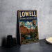 A vintage metal sign for Lowell National Historical Park in Massachusetts, featuring an illustration of the park's buildings and a river.