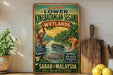 a vintage-style travel poster advertising the Kinabatangan- Segama Wetlands in Sabah, Malaysia, with an illustration of an orangutan, a boat, and a crocodile.