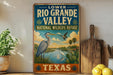 A vintage-style sign for the Lower Rio Grande Valley National Wildlife Refuge in Texas, featuring an illustration of a heron and other wildlife in a natural setting.