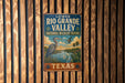 A vintage-style metal sign for the Lower Rio Grande Valley National Wildlife Refuge in Texas, featuring an illustration of a heron and other wildlife in a natural setting.