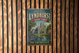 A vintage-style metal sign that reads "Welcome to Lyndhurst New York" with a castle illustration, mounted on a wooden wall.