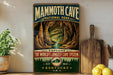 A vintage-style metal sign for Mammoth Cave National Park, featuring an illustration of the cave system and the text "EXPLORE THE WORLD'S LONGEST CAVE SYSTEM EST. 1941 KENTUCKY U.S.A."