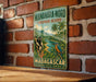 A vintage-style metal sign with a tropical landscape and wildlife, mounted on a brick wall.