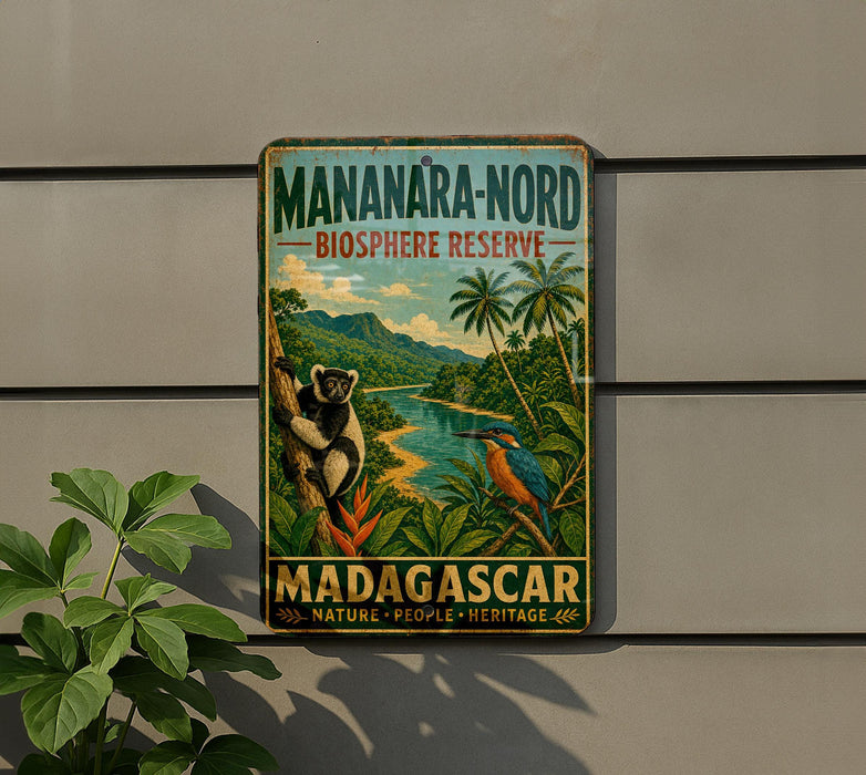 A vintage-style sign for the Mananara-Nord Biosphere Reserve in Madagascar, featuring a lush tropical landscape with a monkey and a bird.