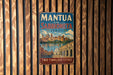 A vintage metal sign with the text "MANTUA AND SABBIONETA ITALY" and "TWO TIMELESS CITIES" is displayed on a wooden wall.