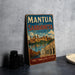 A vintage metal sign advertising "Mantua and Sabioneta Italy" is displayed on a table, with a stack of black camera lenses and a white dish visible in the background.