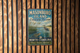 A vintage-style metal sign for Masonboro Island Estuarine Reserve in North Carolina, featuring a seagull and a turtle in a grassy area.