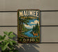 A metal sign with the text "MAUMEE STATE FOREST OHIO" and an illustration of a deer in a forest setting.
