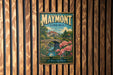 A vintage metal sign for Maymont, Virginia, featuring a scenic illustration of a bridge, flowers, and a house, mounted on a wooden wall.