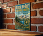 A vintage-style metal sign advertising the Medicine Bow-Rout National Forests in Colorado and Wyoming, featuring a mountain landscape and text promoting outdoor activities.
