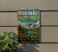a vintage-style metal sign advertising Medicine Bow-Rout National Forests in Colorado and Wyoming, with a mountain landscape and a lake in the background.