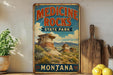 A vintage-style sign for Medicine Rocks State Park in Montana, featuring a scenic landscape with rock formations and mountains.