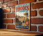 A vintage metal sign with the text "Medieval City of Rhodes Greece" and a castle illustration, mounted on a brick wall.