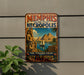 A vintage-style metal sign advertising "Memphis and its Necropolis" and "The Pyramid Fields Giza to Dahshur Egypt" is displayed on a wall, with a plant visible to the left.
