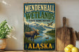 A vintage-style sign for Mendenhall Wetlands State Game Refuge in Alaska, featuring a moose and a duck in a scenic landscape.