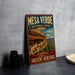 A vintage-style metal sign for the Mesa Verde National Park in the United States, featuring an illustration of the ancient cliff dwellings of the park.