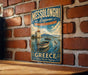 A vintage-style metal sign for Messolonghi Lagoon in Greece, featuring a scenic illustration of a boat on a lake with a windmill in the background.