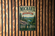 A vintage-style metal sign for the Michaux State Forest in Pennsylvania, featuring a scenic landscape with pine trees and a river.