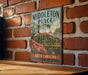 A vintage-style metal sign for "Middleton Place" in South Carolina, featuring a brick wall and a house with a palm tree in the background.