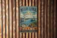 A vintage-style metal sign for the Mission-Aransas National Estuarine Research Reserve in Texas, featuring an illustration of a crane, a turtle, and a boat on a body of water.