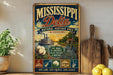 A vintage-style poster advertising the Mississippi Delta National Heritage Area in Mississippi, featuring illustrations of a river, a house, a boat, and musical instruments.