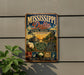 A vintage-style metal sign for the Mississippi Delta National Heritage Area in Mississippi, featuring illustrations of a river, a steamboat, cotton, and a guitar.