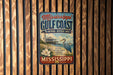 A vintage-style sign for the Mississippi Gulf Coast National Heritage Area, featuring a lighthouse, a bird, and a coastal scene.