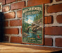 A vintage-style metal sign for the Mohican Memorial State Forest in Ohio, featuring a scenic image of a river and forest.