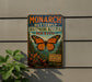 A vintage-style metal sign with a butterfly design, advertising the Monarch Butterfly Biosphere Reserve in Mexico.