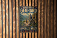 A vintage metal sign with the text "MONASTERY OF GEGHARD AND THE UPPER AZT VALLEY ARMENIA" is displayed on a wooden wall.