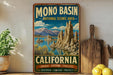 A vintage-style sign for the Mono Basin National Scenic Area in California, featuring a scenic landscape with mountains, water, and a lake.