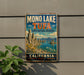 A vintage metal sign for the Mono Lake Tufa State Natural Reserve in California, featuring a scenic landscape with mountains, water, and vegetation.