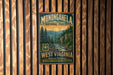 a vintage-style metal sign for Monongahela National Forest, which is hanging on a wooden wall.