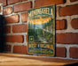 A vintage-style metal sign for Monongahela National Forest, featuring a scenic mountain landscape with pine trees and a river.