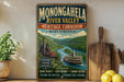 a vintage-style sign for Monongahela River Valley, West Virginia, with a scenic illustration of a river, bridge, and buildings.
