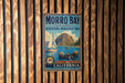 A vintage metal sign for Morro Bay State Marine Recreational Area, featuring a sailboat and sea otters, is displayed on a wooden wall.