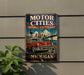 A vintage-style metal sign that reads "Motor Cities National Heritage Area" and "Michigan", featuring an illustration of a classic car and a bridge.