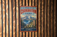 A vintage metal sign for Mount Changbai Park in China, featuring a scenic mountain landscape and the words "Nature, Adventure, Discovery" in bold text.