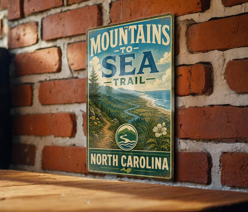 A vintage metal sign on a brick wall, advertising the "Mountain to Sea Trail North Carolina".