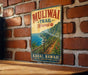 A vintage-style metal sign with the text "Muliwai Trail Hawaii" and "Kauai, Hawaii" printed on it, hanging on a brick wall.