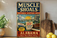 a vintage-style metal sign with text and illustrations related to the Muscles Shoals National Heritage Area in Alabama.